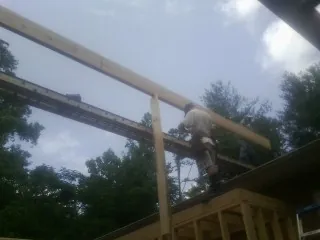 Carpenter setting a ridge beam over a new addition frame — Ice Dam Removal by Roofing Brothers in Ashville